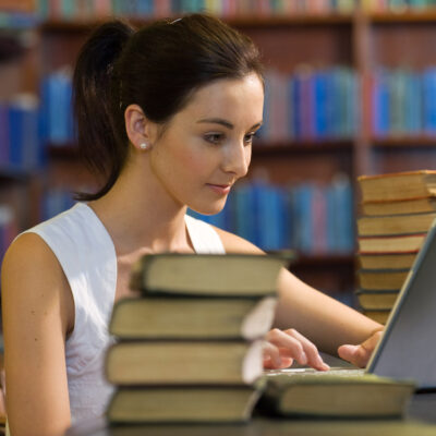 College Student Studying in Library --- Image by © Peter M. Fisher/Corbis